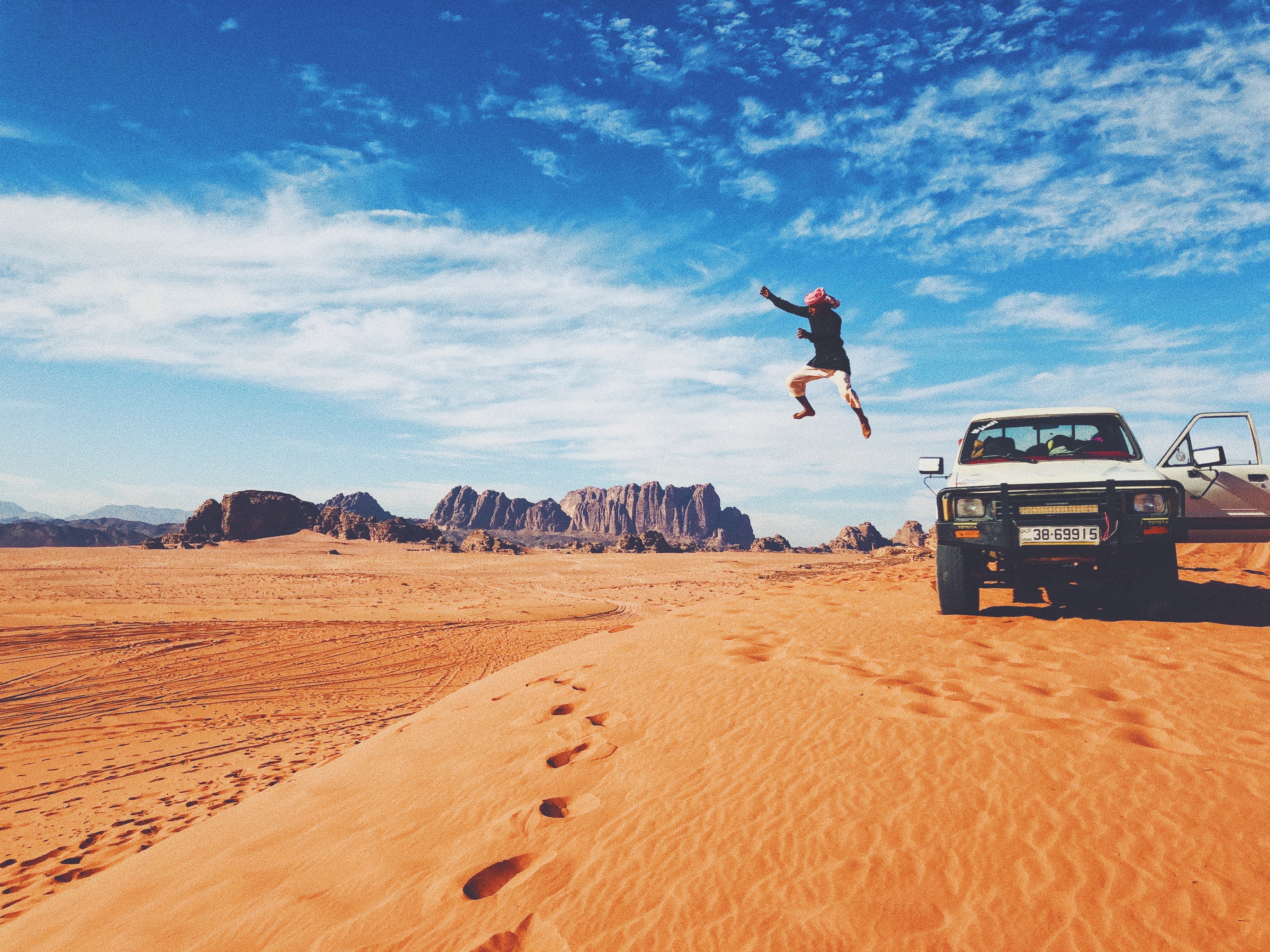 man jumping off of a jeep